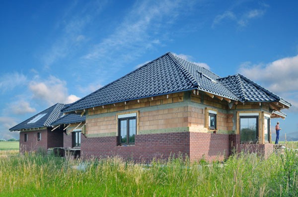 Budowa ściany trójwarstwowej w dwóch etapach izolację z wełny i elewację układa się dopiero-po pokryciu dachu