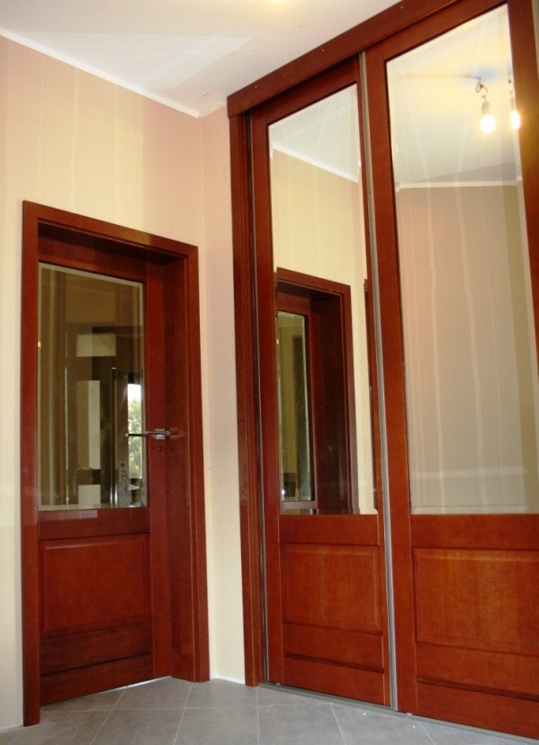 Ten sam wzór drzwi wewnętrznych i drzwi szafy wnękowej sprawia, że w pomieszczeniu panuje harmonia. W szafie zamontowane zostały lustra.  Fot. CAL