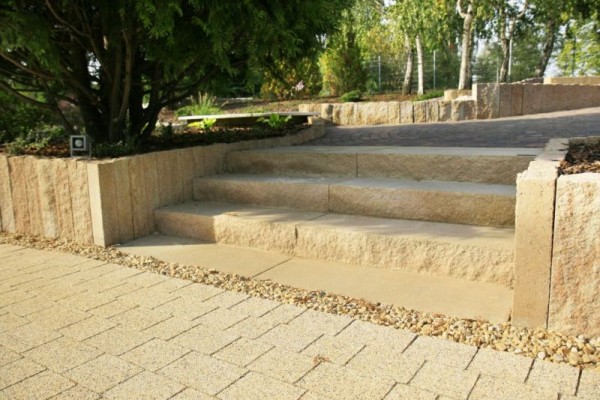Do wykonanie schodów ogrodowych można zastosować różne materiały i technologie. Najprostszą są gotowe elementy schodowe. Na zdjęciu stopnie łamane (splitowane) w kolorze pastello z rodziny Libet Completto